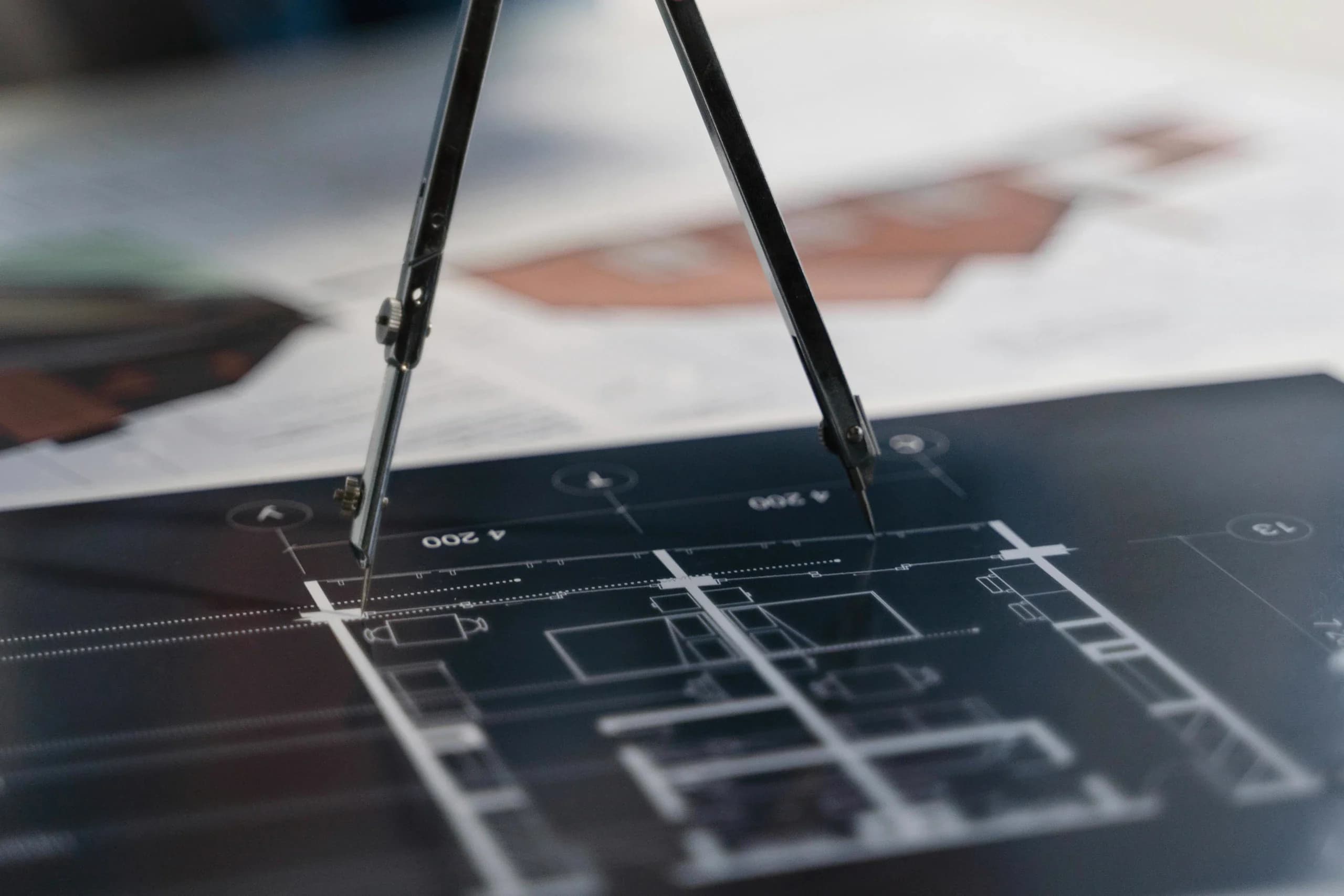 Drafting compass resting on architectural floor plans